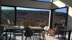Un área de comedor con una mesa y sillas, una silla de mimbre y una silla con estampado de cebra.