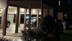 Een tweelaags gebouw met een balkon, een parkeerplaats en een bord waarop 'CREAM BALL' staat.