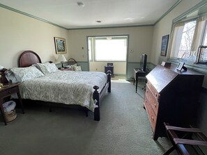 Une chambre à coucher comprenant un lit, une commode, un bureau, une chaise et une fenêtre.