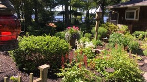 A garden with various plants and a wooden fence. - Nancy’s Touch, A Waterfront Paradise! (North East)