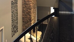 Un escalier avec un mur en pierre et une citation inspirante.