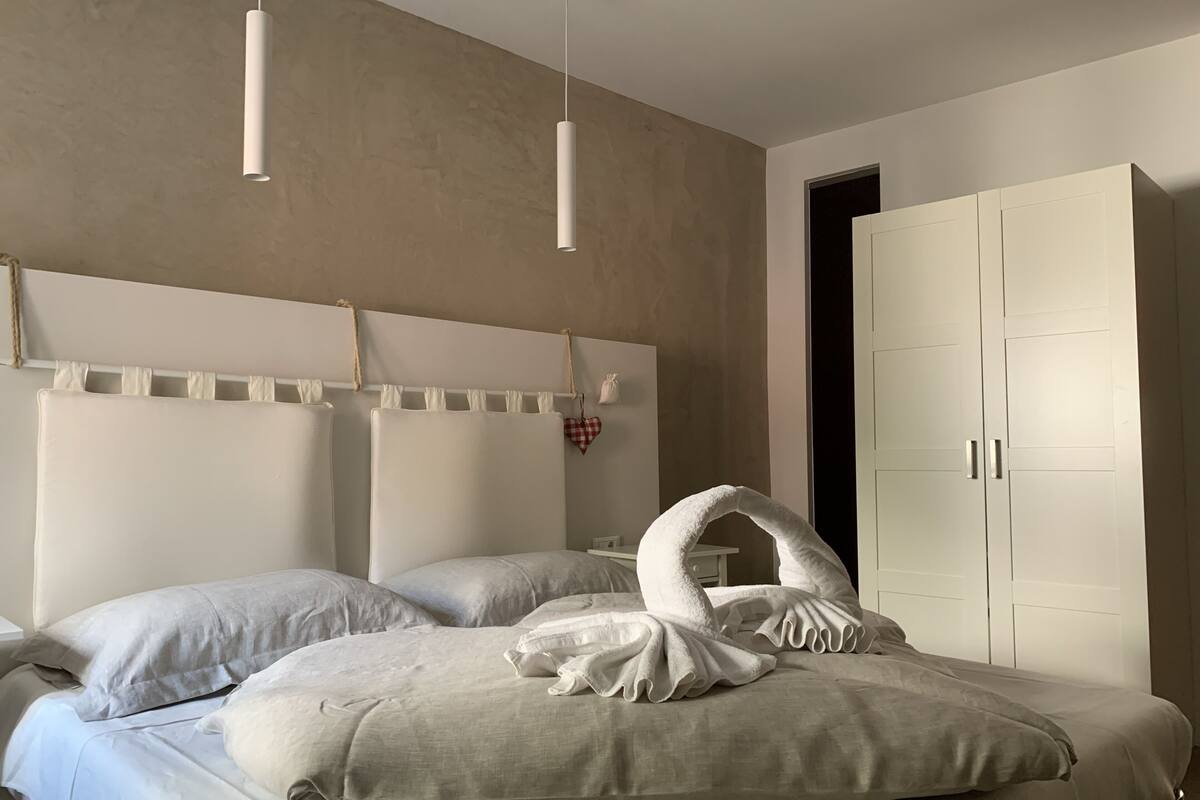 Ein Schlafzimmer mit einem großen Bett, einem weißen Kopfteil und einem Kleiderschrank.