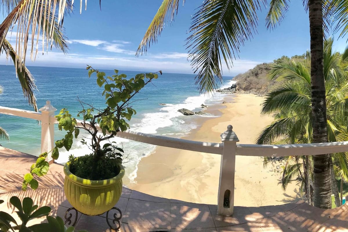 A balcony with a view of a beach and ocean.