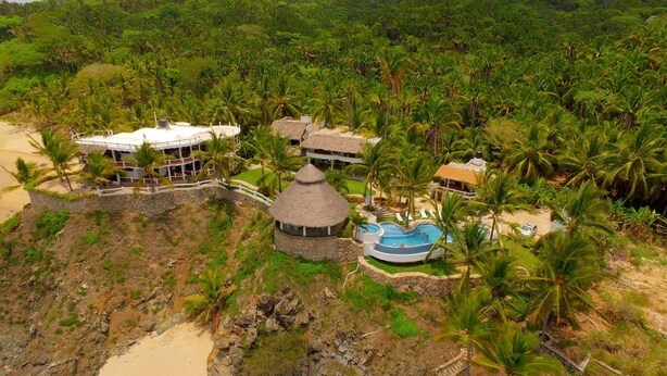 A resort with multiple buildings surrounded by palm trees and a beach. - Bungalows Lydia (San Francisco)