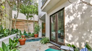 A courtyard with a pool, potted plants, a green bench, and a sliding glass door. - Artist’s Library; Private Swimming Pool in River Oaks Area (Houston)