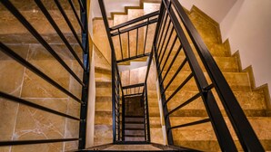 Una escalera con barandilla de metal que baja a un nivel inferior.