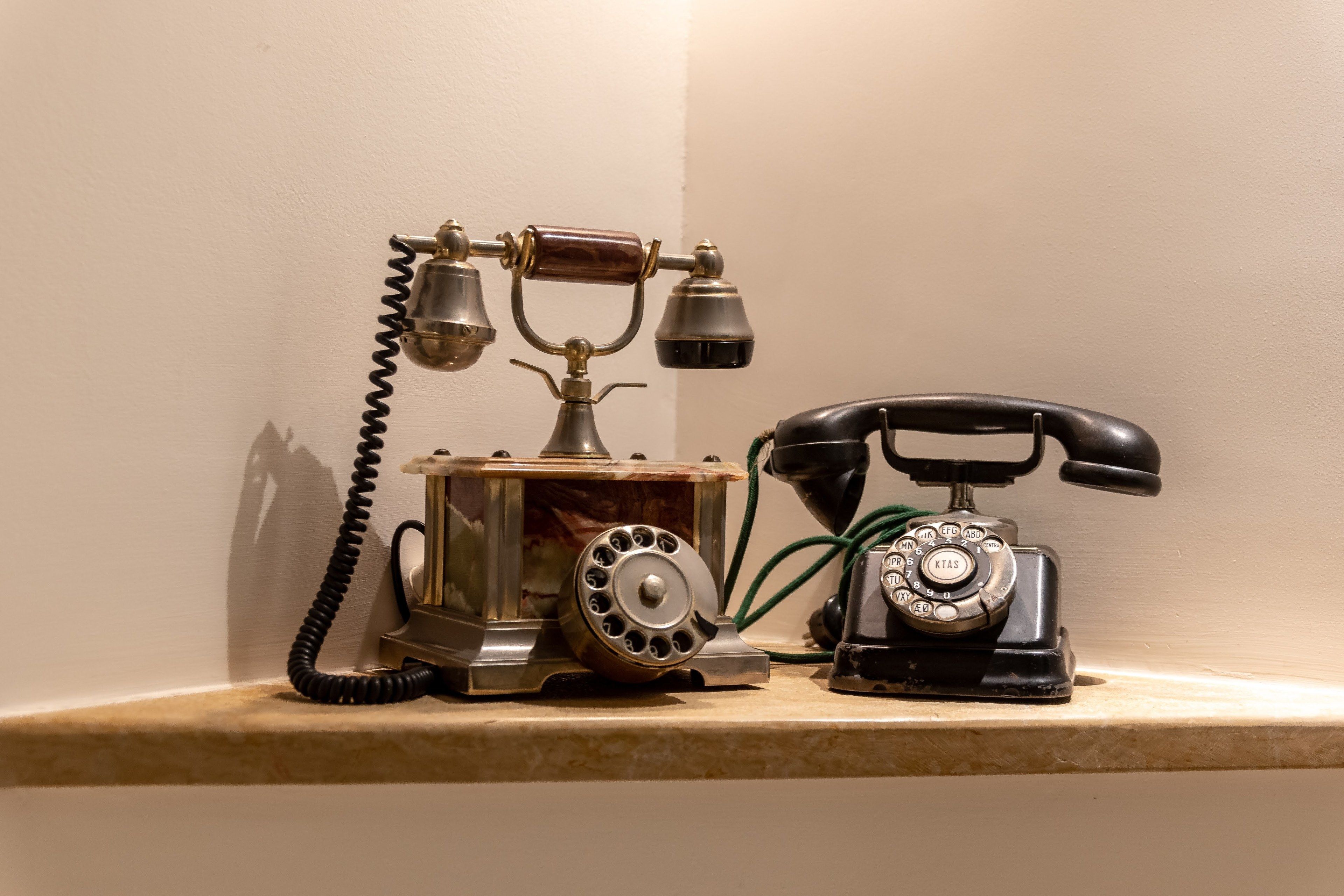 Un teléfono antiguo sobre una estantería.