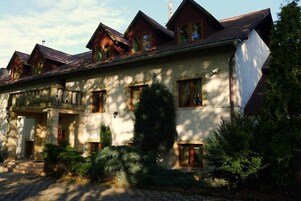 Um edifício em estilo chalé tradicional, com várias janelas e fachada de pedra.
