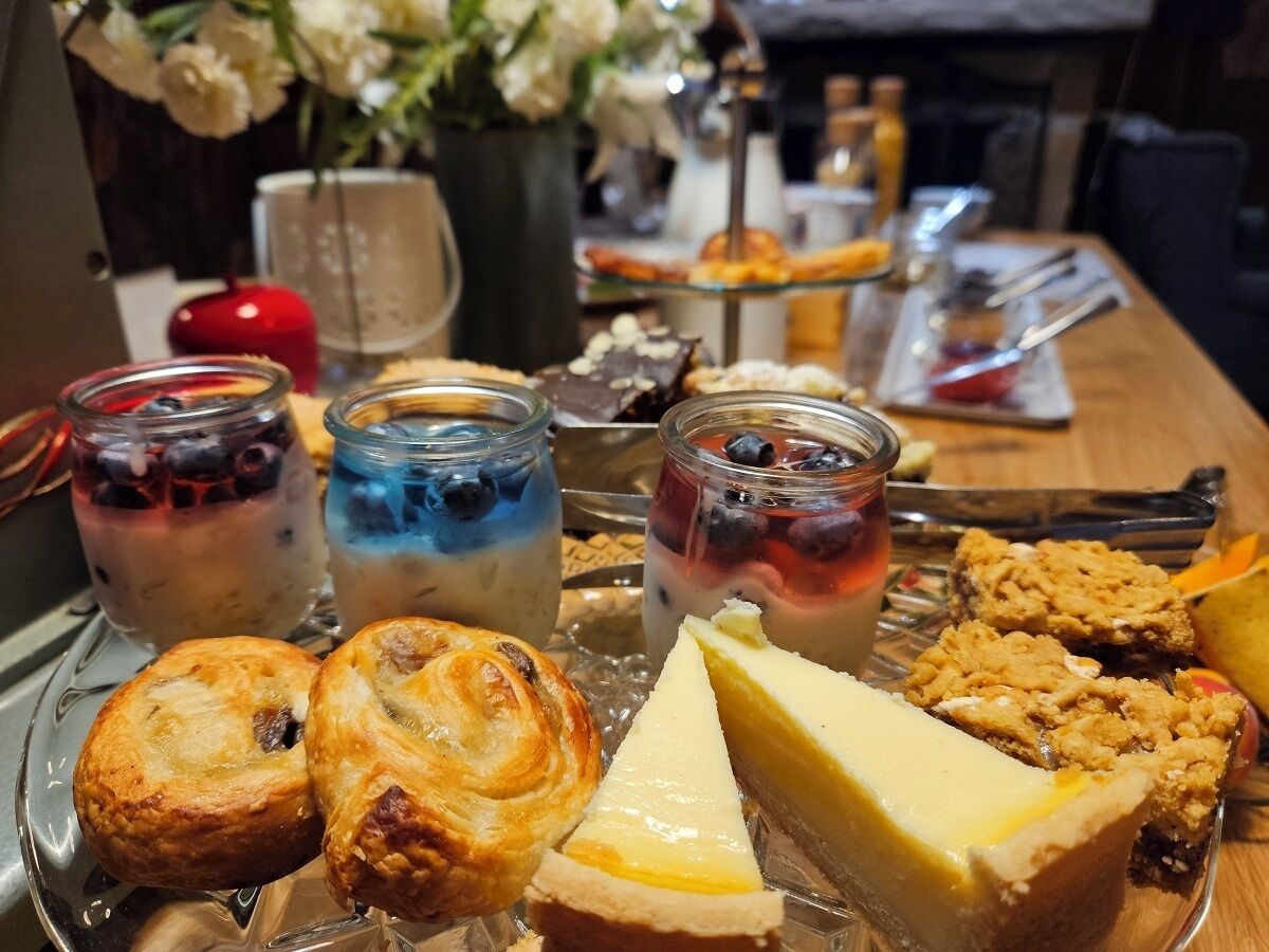 A table with various pastries, desserts, and beverages.
