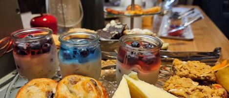 A table with various pastries, desserts, and beverages.