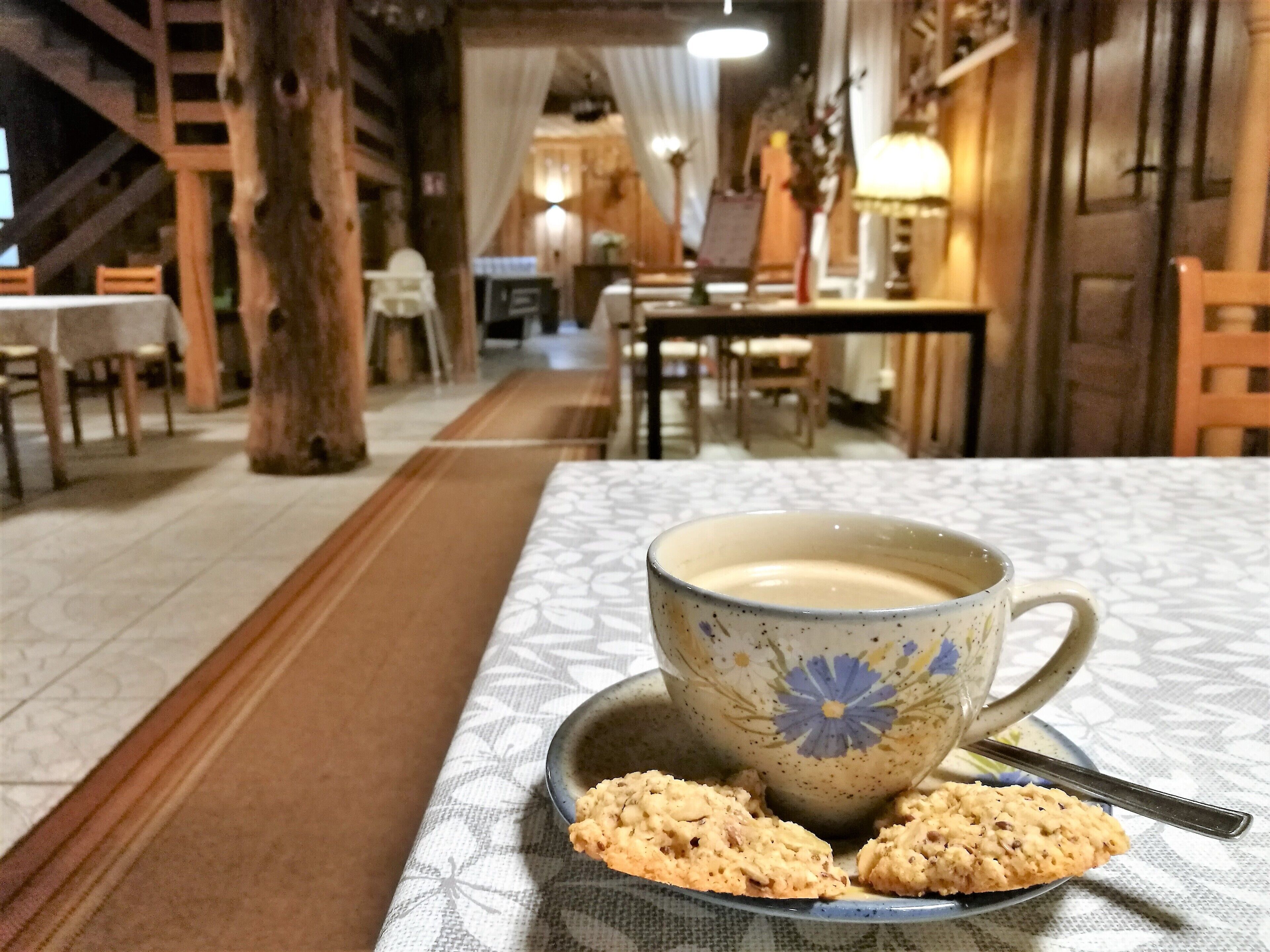 Un rincón comedor acogedor con una mesa lista para dos, con una taza de café y galletas.