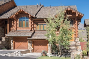 Une cabane en rondins avec des fondations en pierre, un grand garage et une fenêtre bien visible.