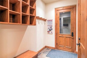 Una puerta de madera con un panel de vidrio, una estantería de madera y un cartel en la pared.