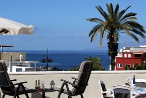 A terrace with two chairs, a table, and a view of the sea. - Alcalá Plaza (Alcalá)