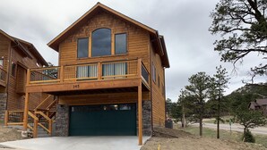 Ein zweistöckiges Holzhaus mit Balkon, Garage und Auffahrt.