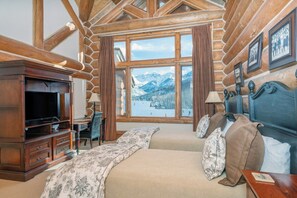 A log cabin room with a bed, a desk, and a television. - Villas At Tristant 221 (Mountain Village)