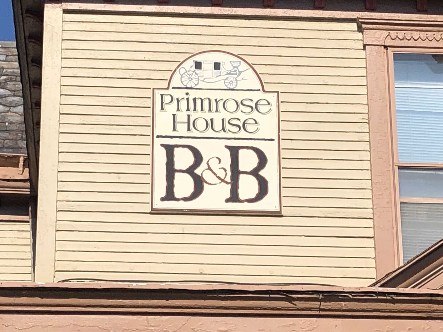 A sign for Primrose House B&B with a logo above the name.
