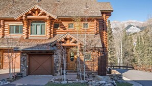 A log cabin with a garage, a front porch, and a mountain backdrop. - Villas At Tristant 127 (Mountain Village)