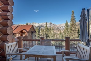 Une cabane en bois dotée d’un balcon donnant sur un paysage montagneux.