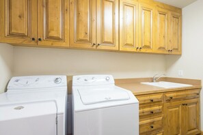 A laundry area with two white washing machines and a sink. - Villas At Tristant 215 (Mountain Village)