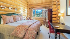 A log cabin bedroom with a bed, desk, and dresser. - Villas At Tristant 215 (Mountain Village)