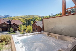 Un bain à remous avec vue sur une montagne et une cabane en bois.
