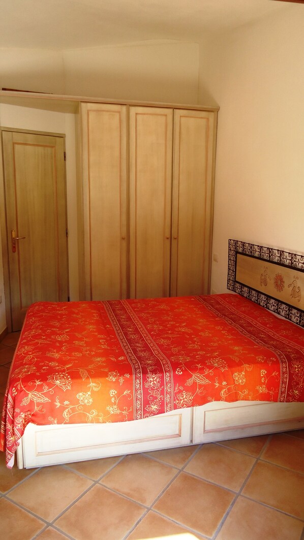 Un dormitorio con cama, armario y puerta.