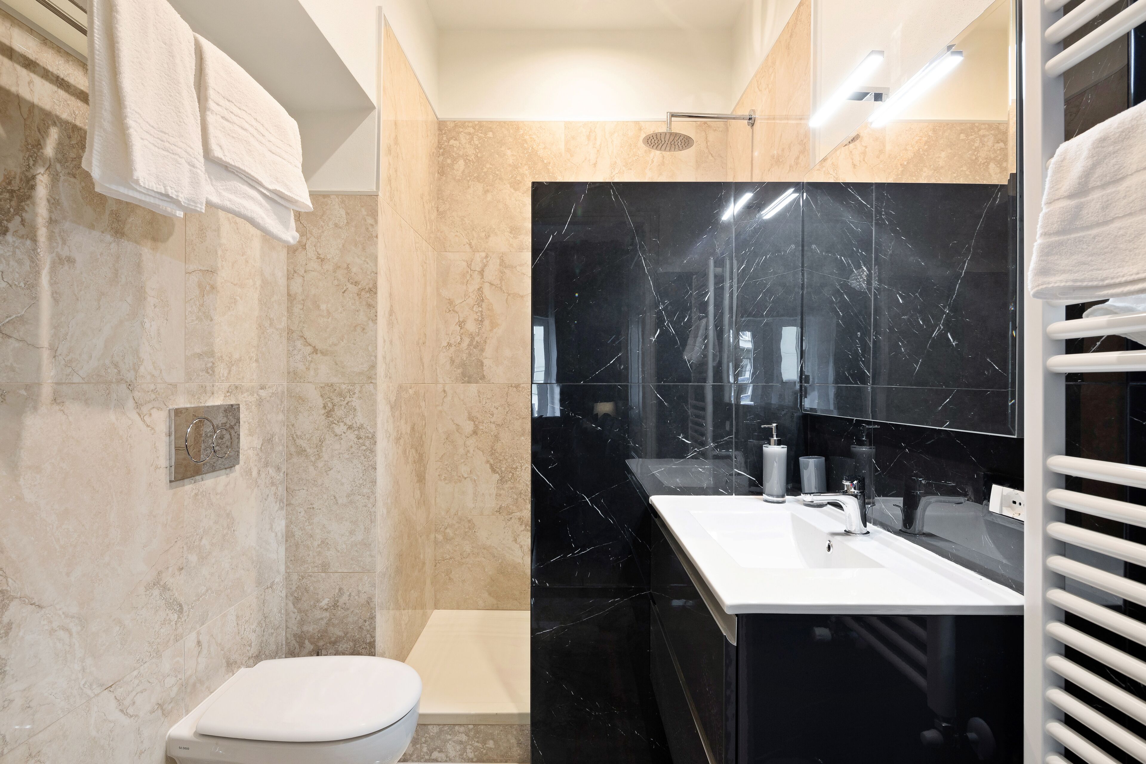 A modern bathroom with a toilet, sink, and shower area.