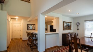 A spacious dining area with a high ceiling, wooden flooring, and a view of the kitchen through an open doorway. - Spacious, private home .6 mi from downtown Ketchum (Ketchum)