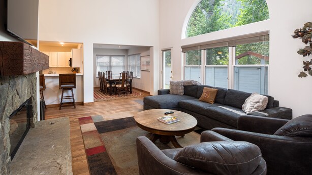 A spacious living area with a fireplace, a large round coffee table, and a comfortable seating arrangement. - Spacious, private home .6 mi from downtown Ketchum (Ketchum)