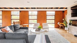 A modern living room with a sectional sofa, a round coffee table, and a fireplace.