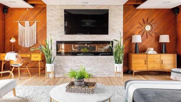 A modern living room with a fireplace, wooden accents, a flat-screen TV, and a cozy seating area.