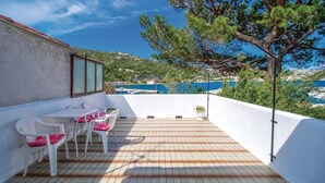 A terrace with a table and chairs, a view of the sea, and a tree. - Stunning home in Bakarac with house sea view (Bakarac)