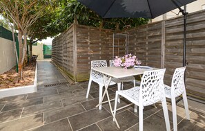 A patio with a table and chairs, a flower arrangement, and a wooden fence. - Pet friendly home in Aleria with WiFi (Aleria)