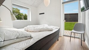 A bedroom with a bed, a chair, a window, and a view of the outdoors. - Beautiful home in Haderslev with sauna (Haderslev)