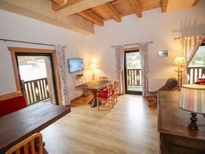 Relax in a warm and inviting space with a mounted TV, dining table, and comfortable seating.