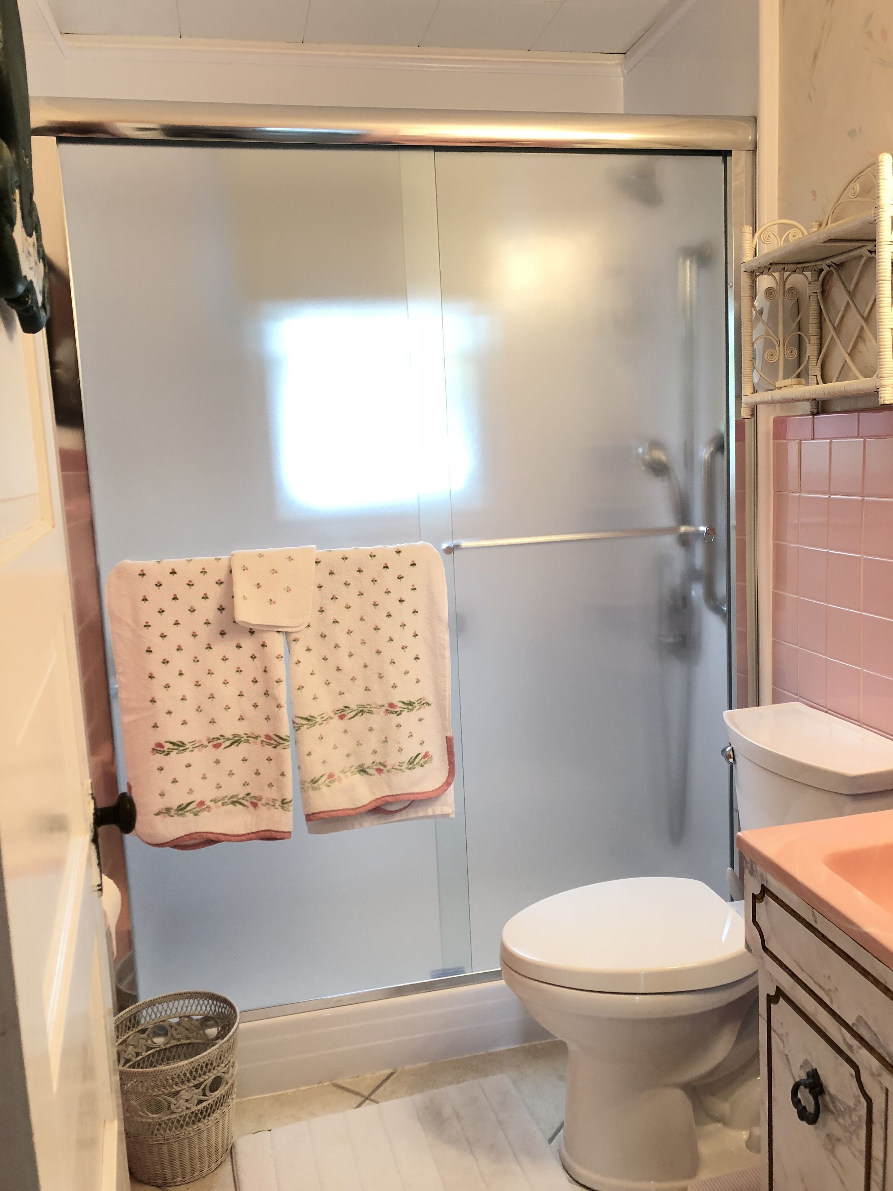 A bathroom with a shower, toilet, and a sink.