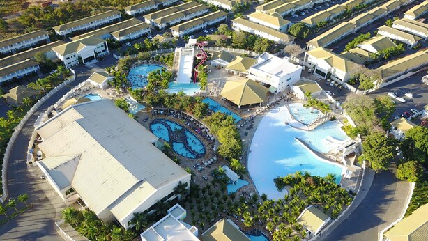 An aerial view of a resort with multiple swimming pools, a water slide, and a variety of buildings with flat roofs. - Lacqua diRoma Hotel e Parque Aquático (Caldas Novas)