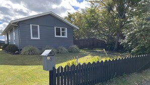 A residential house with a dark gray exterior, white window frames, and a mailbox with a 'No Junk Mail' sign. - Take time out in Turangi - family friendly (Turangi)