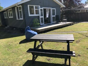 A backyard with a wooden picnic table and a blue bean bag chair. - Take time out in Turangi - family friendly (Turangi)