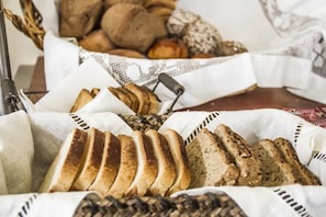 Una cesta con rebanadas de pan y diferentes tipos de pan al fondo.