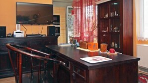A dining area with a wooden table, chairs, a television, and a bookshelf. - Vienna waits for you by Interhome (Vienna / 5. District)