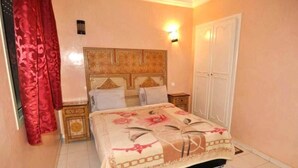 A bedroom with a bed, nightstands, a wardrobe, and a red curtain. - Residence Atlas Marrakech 3542 (Marrakech)