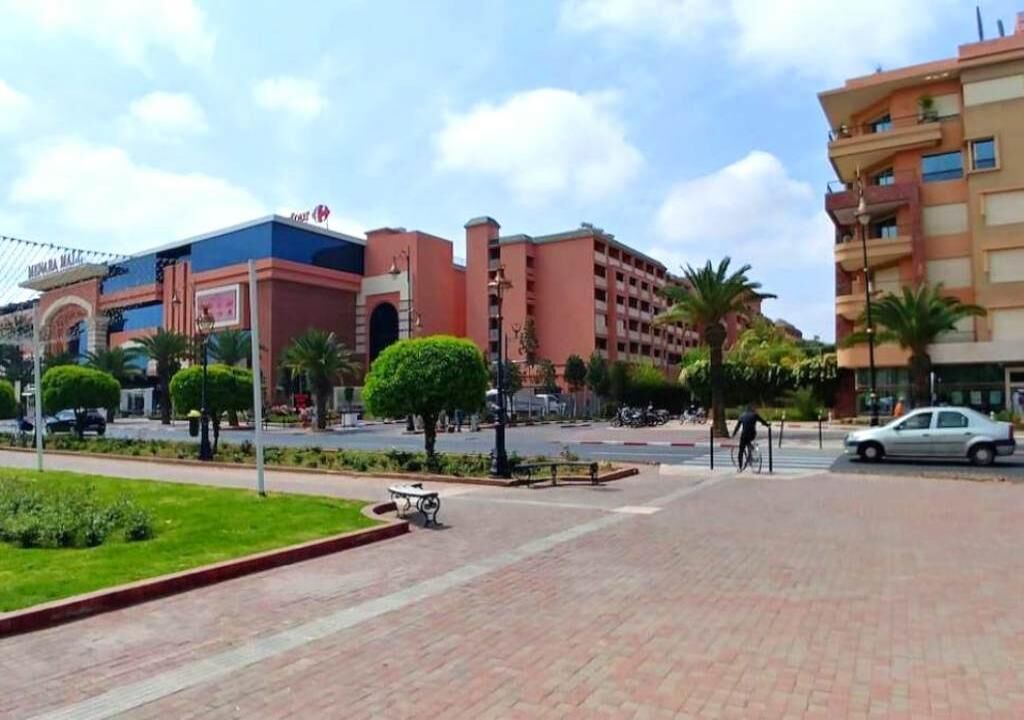 A hotel with a modern design, featuring a prominent entrance and a parking area.