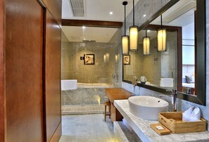 A modern bathroom with a large sink, a bathtub, and a glass-enclosed shower area.