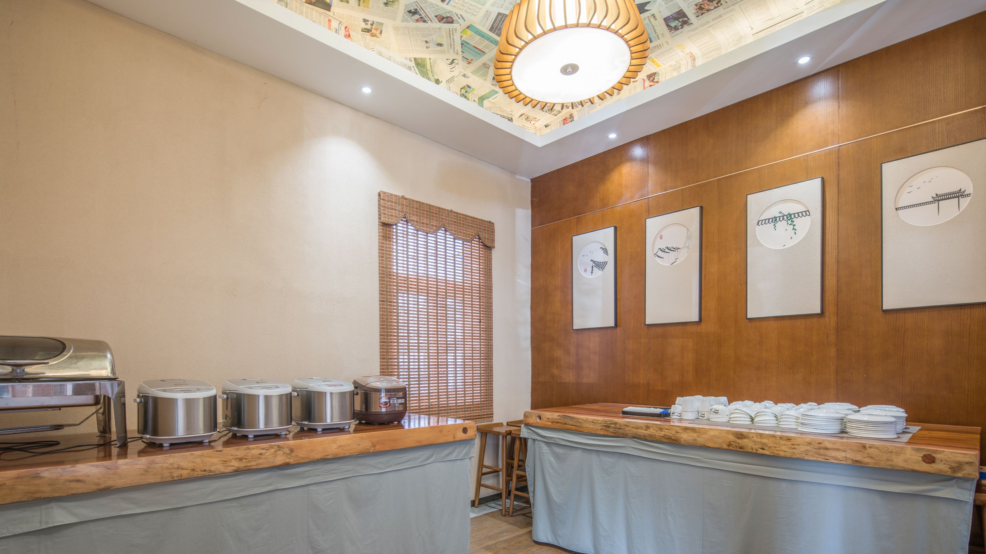 A breakfast area with a wooden counter, stainless steel appliances, and a ceiling with a newspaper map design.