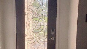 A dark wooden door with a decorative glass panel. - Spacious 4BR 2-Story North Houston Vacation Rental (Tomball)