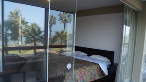 A bedroom with a bed, a nightstand, and a sliding glass door leading to a balcony. - Beautiful turist apartment with BALCONY AND OCEAN VIEWS.  max. 8 persons. (Miraflores)