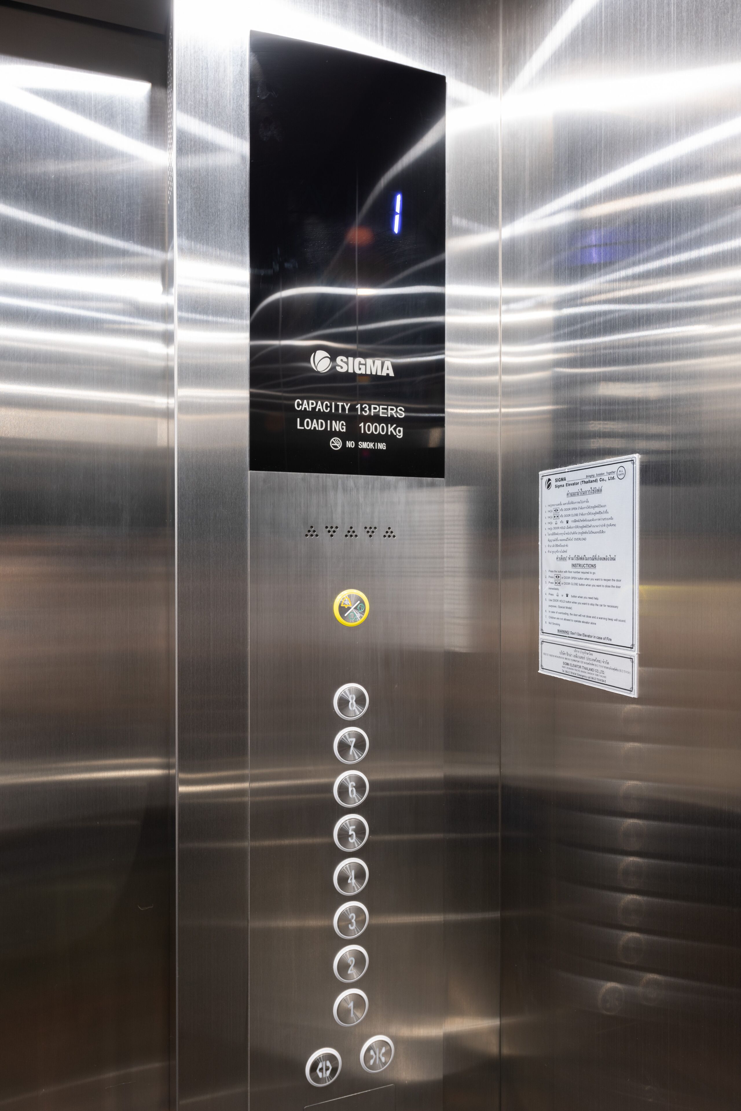 Elevatorinteriør med rustfrit stål, digitalt display og knapper til valg af etage.