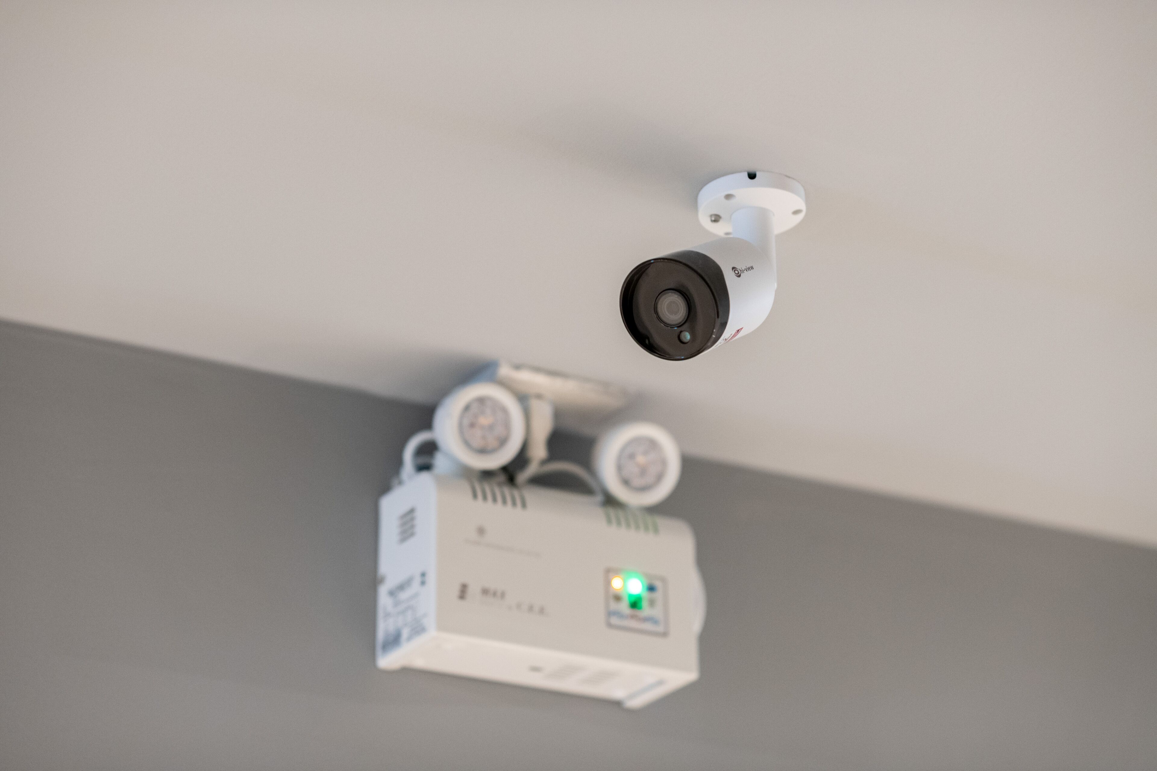 A ceiling-mounted security camera and projector system.